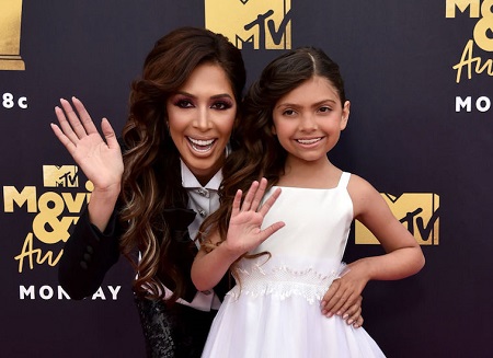 Farrah Abraham with her daughter waving their right hands to the camera at an MTV Movie & Awards show.