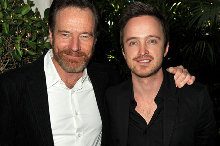 Bryan Cranston and Aaron Paul stand together to take a photo.