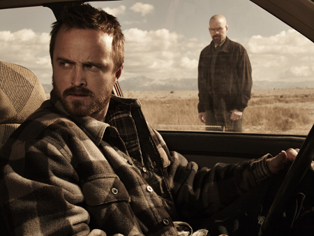 Aaron Paul is in the driving seat as Bryan Cranston looks through the window.