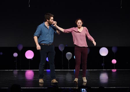 Jake Gyllenhaal kissign the hand of Ruth Wilson while on stage.